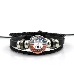 Detail of multi-layer braided leather Route 66 bracelet with glass cabochon charm