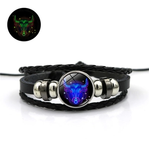 Détail du bracelet multicouche en cuir tressé avec le signe du zodiaque Taureau lumineux