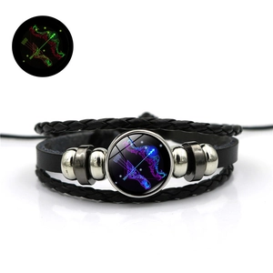 Détail du bracelet en cuir Sagittaire montrant l'effet lumineux vert dans le noir