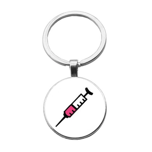 Détail d'un porte-clés infirmière avec illustration de seringue rose et cadre argenté