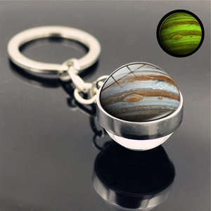 Detailed macro view of Jupiter glass ball keychain with glowing luminous effect in the dark