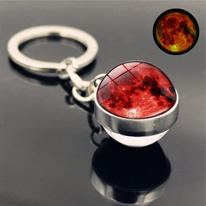 Detailed macro view of the double-sided glass planet keychain with a luminous red moon