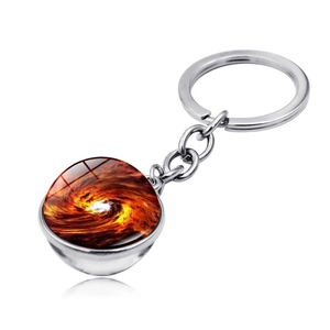 Detailed macro view of the cosmic space nebula glass orb pendant on a silver keychain