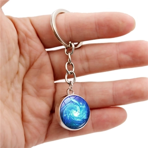 Space vortex double-sided glass ball keychain featuring a cosmic blue spiral galaxy design