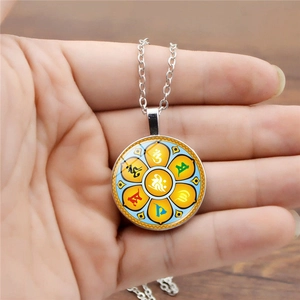 Silver necklace with a round lotus pendant featuring Sanskrit symbols and a blue gemstone