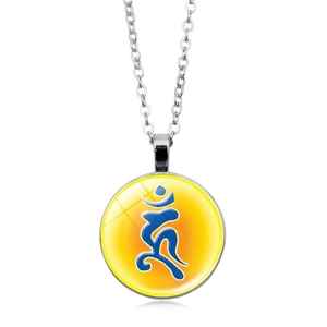 Macro shot of silver religious pendant with yellow gradient background and blue symbol