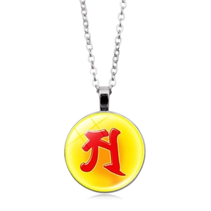 Close-up of circular glass pendant with silver frame and red Sanskrit seed syllable symbol