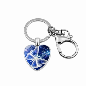 Macro detail of heart-shaped keychain with glowing blue butterfly pattern and silver clasp