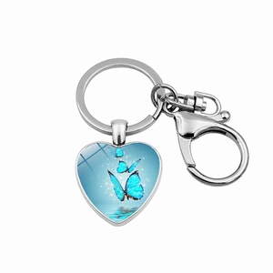 Detail of silver heart keychain with blue butterflies under glass dome and snap hook