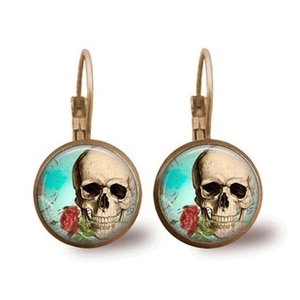 Detailed view of bronze hoop earrings with skull and rose mandala patterns