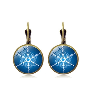 Detail of vintage leverback earrings with white snowflake patterns on blue cabochons