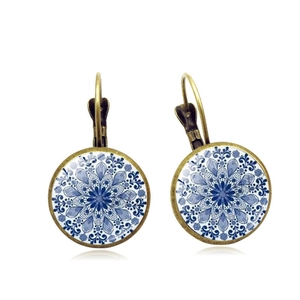 Detailed close-up of vintage bronze mandala earrings with blue floral glass cabochon