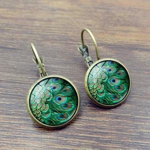 Peacock feather vintage cabochon earrings with silver leverback hooks on wood background
