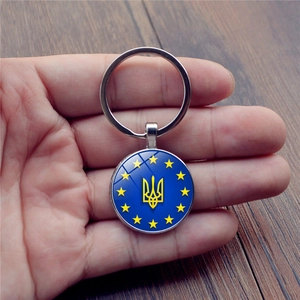 Detail of metal keychain with Ukraine coat of arms pendant and stars in hand