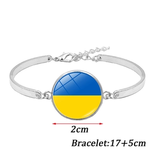 Detailweergave van zilveren armband met Oekraïense vlag glazen hanger en karabijnsluiting