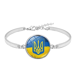 Zilveren armband met vlag van Oekraïne en glazen bedel met trident op witte achtergrond