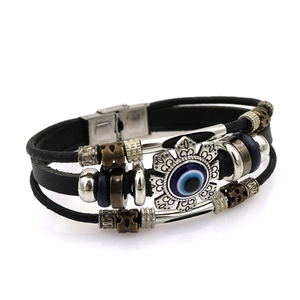Multilayer leather bracelet featuring evil eye sun pendant and metallic charms