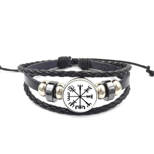 Detail of Viking compass symbol on multilayer braided leather bracelet with silver beads