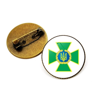Detailansicht der Bronzemetall-Brosche mit Sicherheitsnadel und dem Emblem-Design