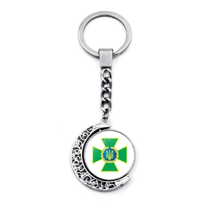 Rotating keychain with Ukraine border guard emblem inside a crescent moon frame