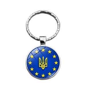 Detailed close-up of a metal Ukraine keychain with trident logo and stars in blue and yellow