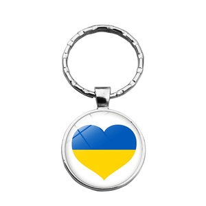 Close-up of heart-shaped Ukraine flag pendant with silver metal keyring and wave texture