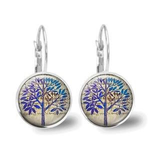 Close-up of tree of life earrings with silver leverback hooks and blue glass pendants