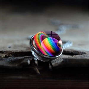 Macro view of galaxy glass pendant necklace featuring nebula patterns on vintage wood