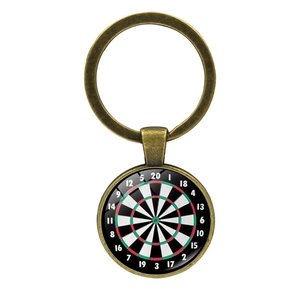Close-up of vintage bronze dartboard keychain with glass dome and scoring numbers