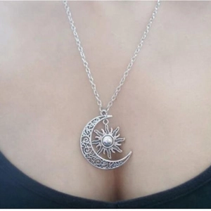 Detail of vintage sun and moon pendant necklace with silver hollow pattern on neck