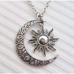 Detailed macro view of vintage silver sun and moon pendant with hollow vine patterns