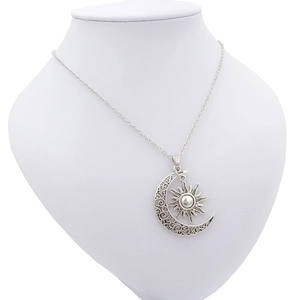 Detail of sun and moon pendant necklace with hollowed silver crescent and star motifs