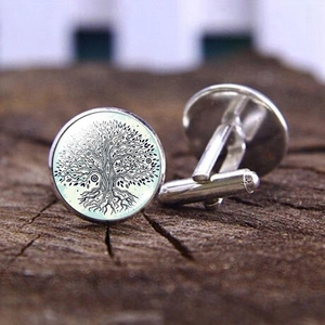 Silver cufflinks with Tree of Life design on mint green background and wooden texture