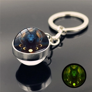 Luminous wolf totem glass ball keychain with polished silver metal base and glowing green effect
