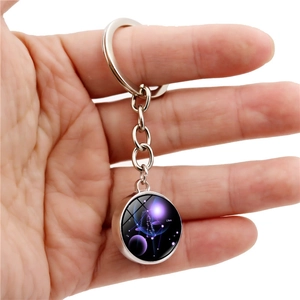 Close-up of Libra zodiac crystal glass keychain with purple starry sky design and metal ring