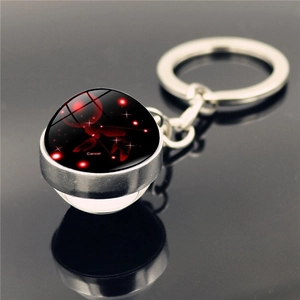 Macro shot of Cancer zodiac crystal glass ball keychain with silver metal base and red motif