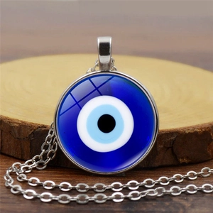 Λεπτομέρεια macro από το τουρκικό μενταγιόν Evil Eye σε ξύλινη βάση με ασημένια αλυσίδα