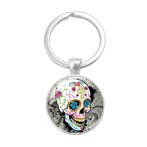 Détail d'un porte-clés tête de mort mexicaine avec pendentif en verre et fleurs