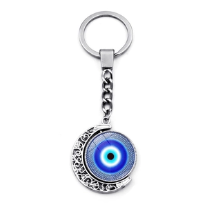 Vue détaillée d'un pendentif œil bleu rotatif sur un porte-clés en forme de croissant argenté