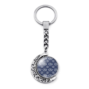 Macro d'un porte-clés lune rotatif argenté avec charme en verre œil bleu turc