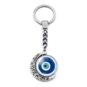 Détail macro du porte-clés lune argentée avec pendentif bleu rotatif mauvais œil