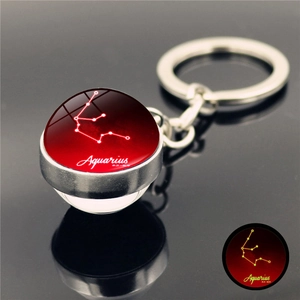 Macro view of Aquarius zodiac keychain with luminous glass sphere and silver ring detail