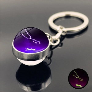 Macro detail of Taurus zodiac glowing crystal ball keychain with purple nebula