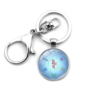 Macro detail of Mandala OM symbol glass dome keychain with silver-finished lobster clasp