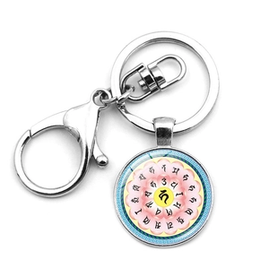 Close-up of mandala flower and OM symbol pendant with metal lobster clasp and key ring