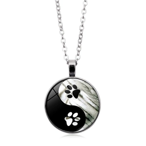 Yin Yang Tai Chi glass pendant necklace with animal paw prints on a silver chain
