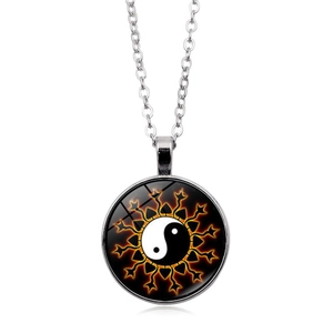 Detailed view of Yin Yang Tai Chi glass pendant with orange flame aura on silver chain