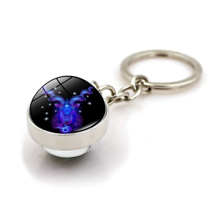 Close-up of Capricorn zodiac keychain with purple neon glass orb and metal ring