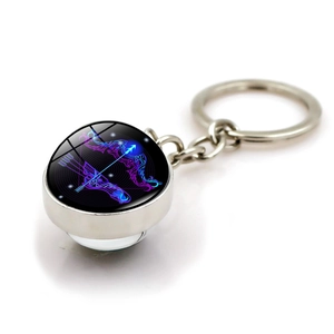 Macro view of Sagittarius glass ball keychain with purple neon constellation art