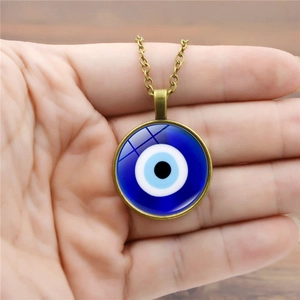 Primer plano del collar turco Evil Eye con colgante de cristal y cadena de bronce antiguo